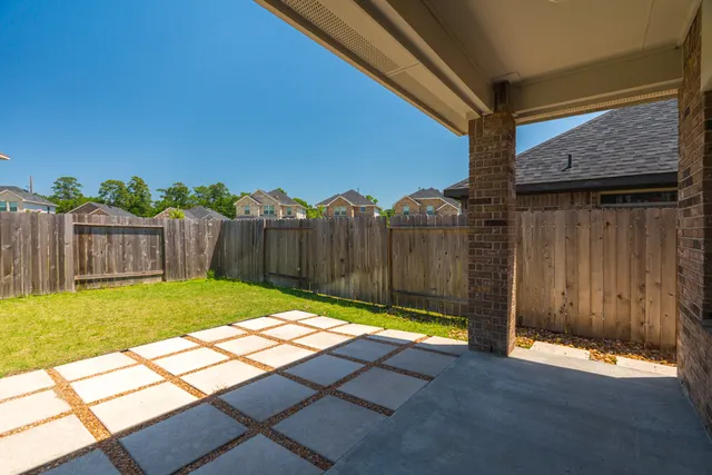 a view of a house with a yard and wooden fence