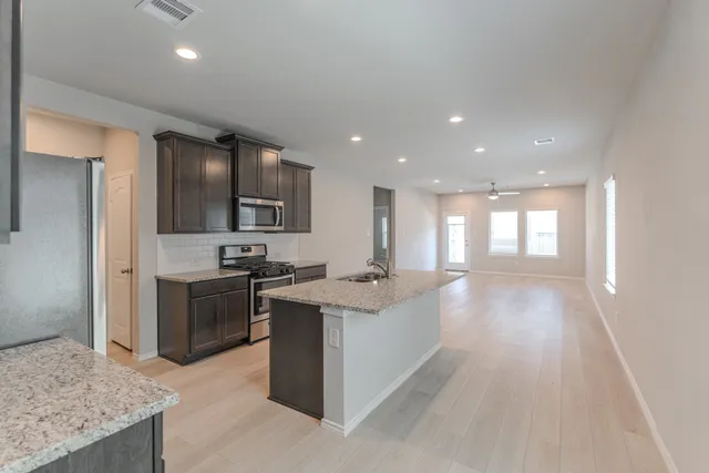 a kitchen with stainless steel appliances granite countertop a sink stove and refrigerator