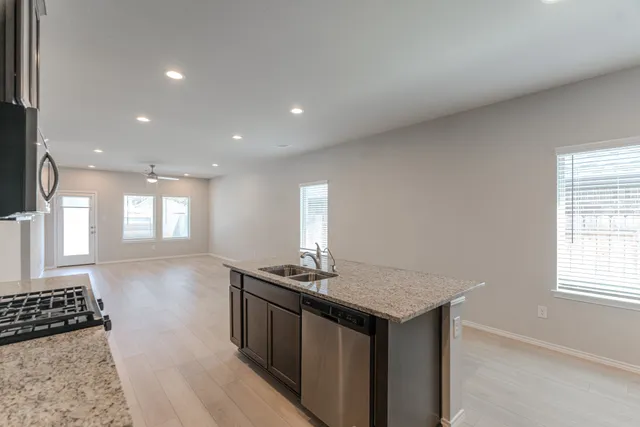 a kitchen with stainless steel appliances granite countertop a sink stove and cabinets