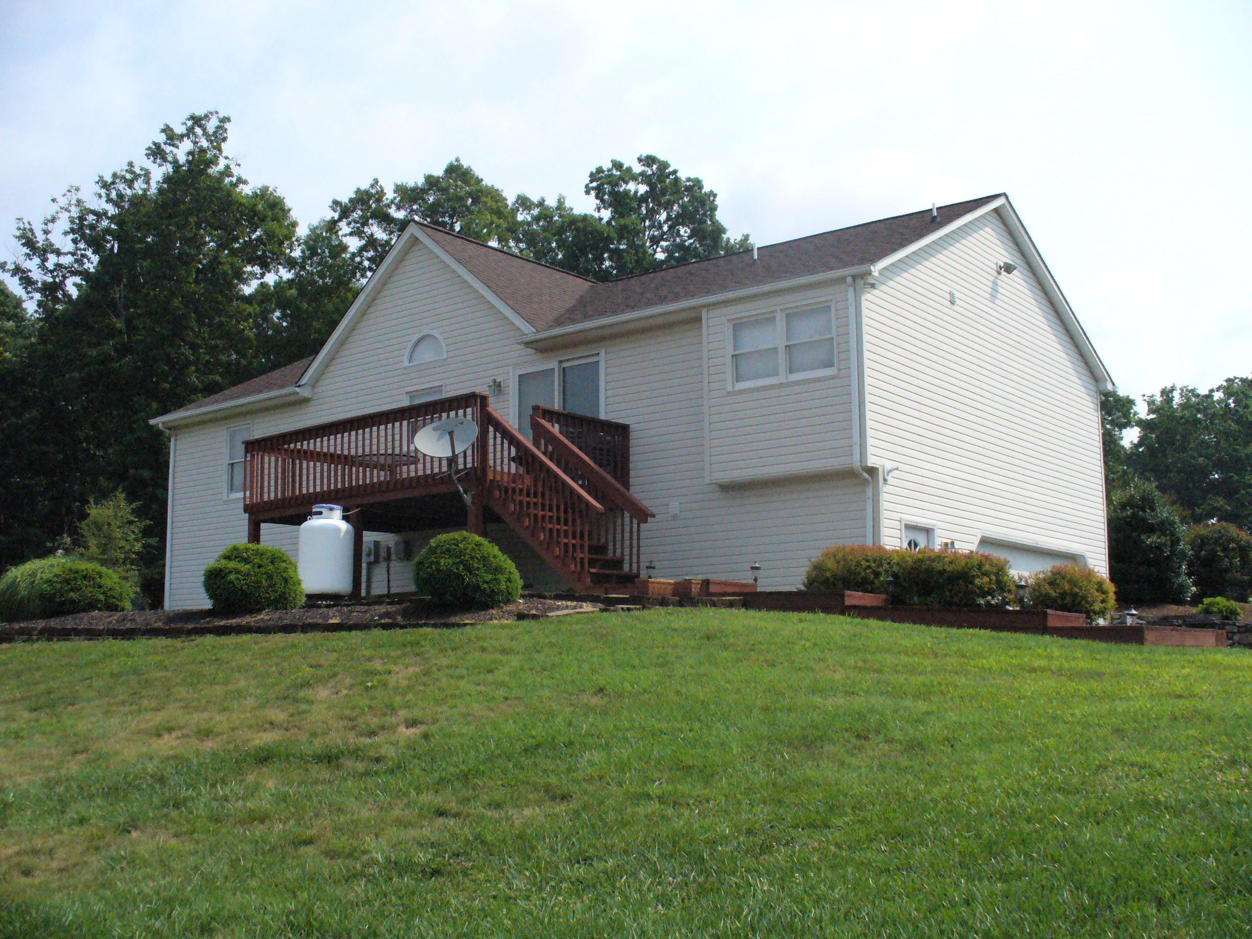 211 Oak Ridge Court Blue Ridge, VA 24064 - Photo 4 of 20 a front view of a house with a yard and garage