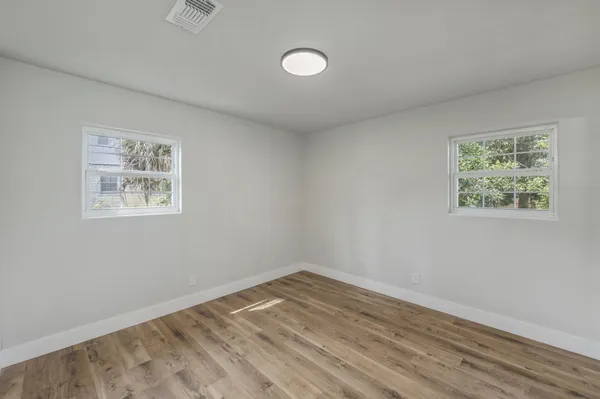 a view of empty room with wooden floor