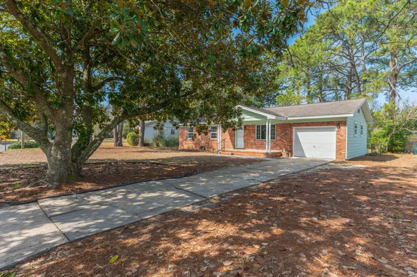 a view of a house with a tree in front of it