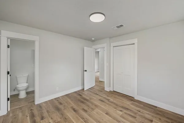 a view of room with a wooden floor and toilet