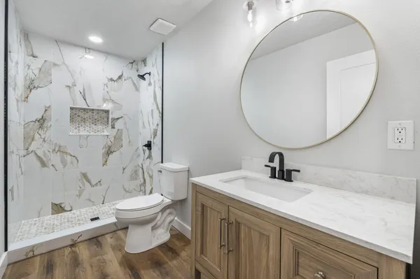 a bathroom with a sink a toilet and a mirror