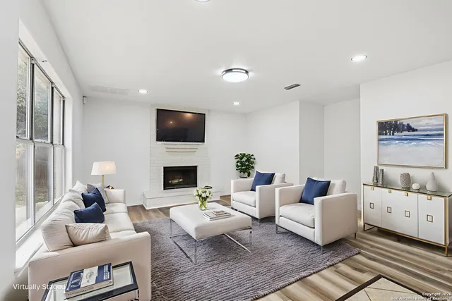 a living room with furniture a fireplace and a flat screen tv