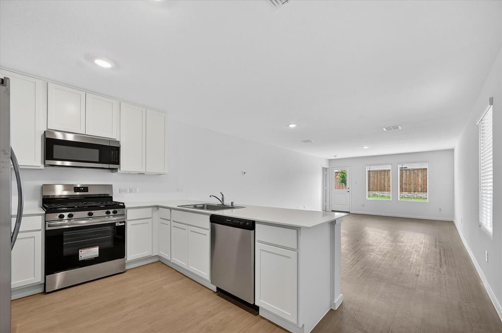 1516 Prince Road Howe, TX 75459 - Photo 7 of 28 a kitchen with stainless steel appliances granite countertop a stove a sink and a microwave