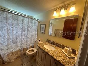 2737 North Poinciana Boulevard, Unit 87 Kissimmee, FL 34746 - Photo 11 of 13 a bathroom with a granite countertop sink toilet and a mirror
