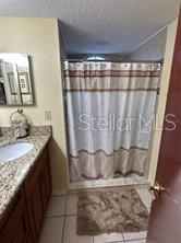 2737 North Poinciana Boulevard, Unit 87 Kissimmee, FL 34746 - Photo 9 of 13 a bathroom with a granite countertop sink and a mirror