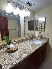2737 North Poinciana Boulevard, Unit 87 Kissimmee, FL 34746 - Photo 10 of 13 a bathroom with a granite countertop sink and a mirror