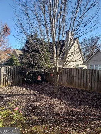 a view of a yard with wooden fence