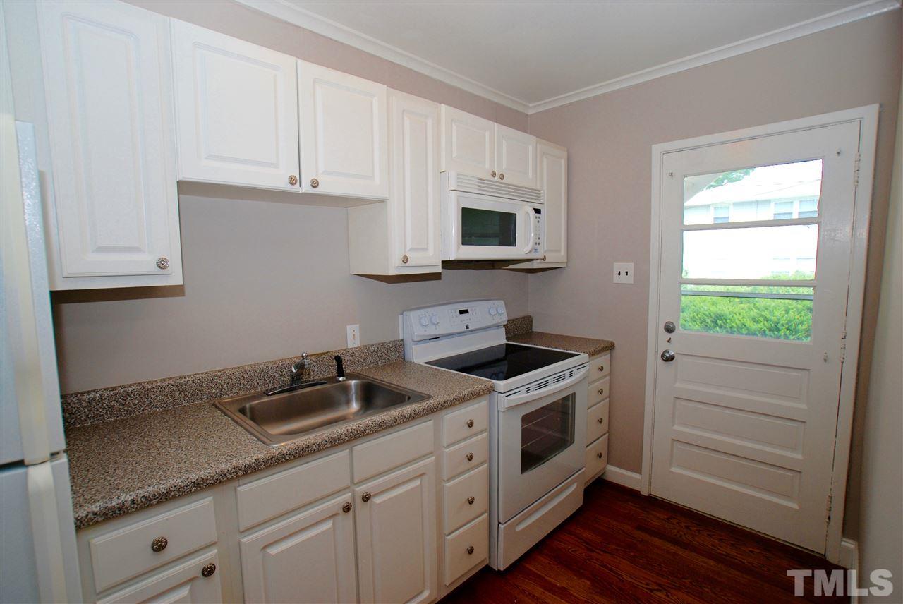 803 Daniels Street, Unit B Raleigh, NC 27605 - Photo 3 of 22 a kitchen with granite countertop white cabinets and a stove with wooden floor
