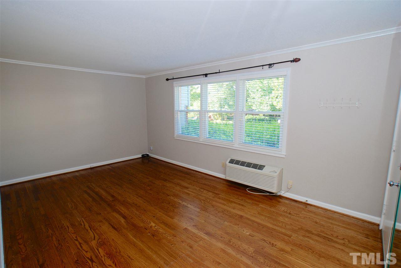 803 Daniels Street, Unit B Raleigh, NC 27605 - Photo 4 of 22 an empty room with wooden floor and windows