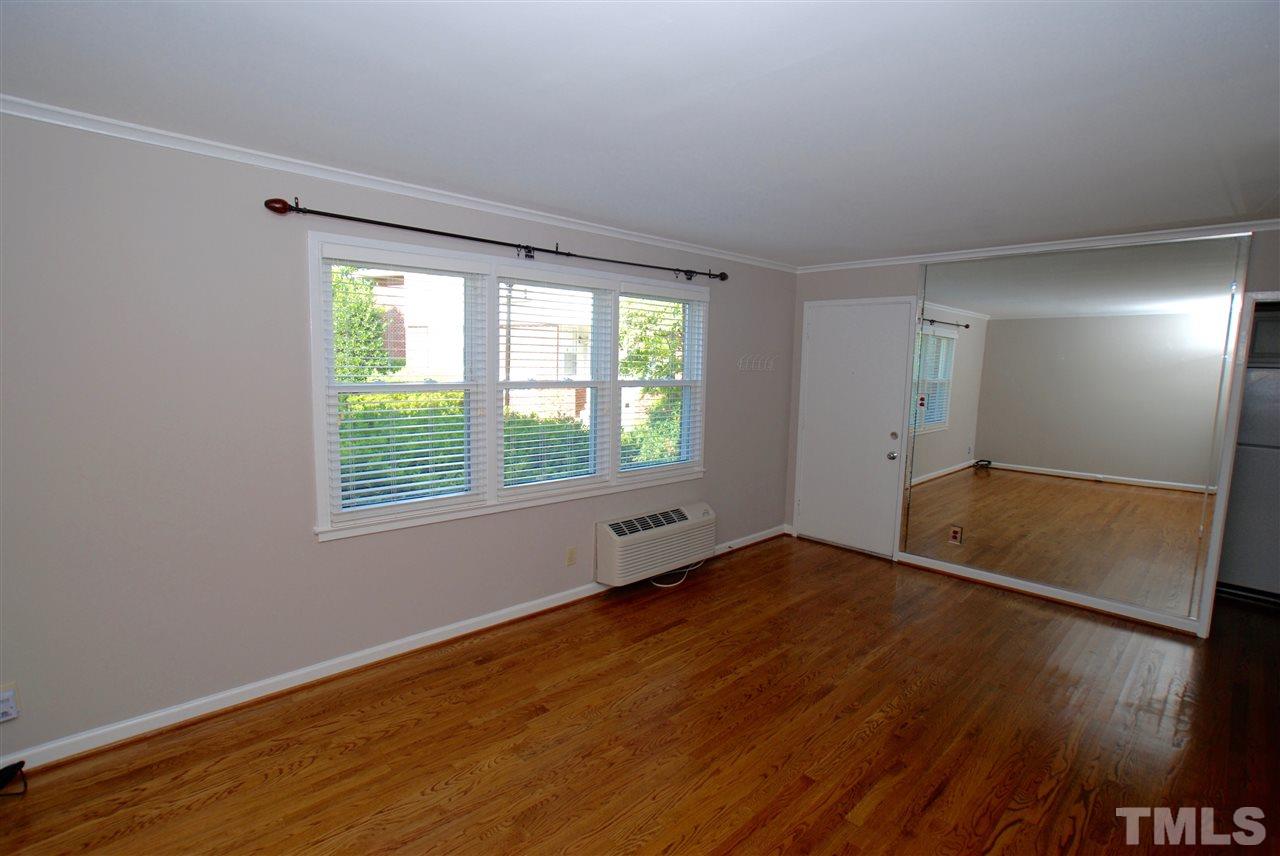 803 Daniels Street, Unit B Raleigh, NC 27605 - Photo 5 of 22 an empty room with wooden floor and windows