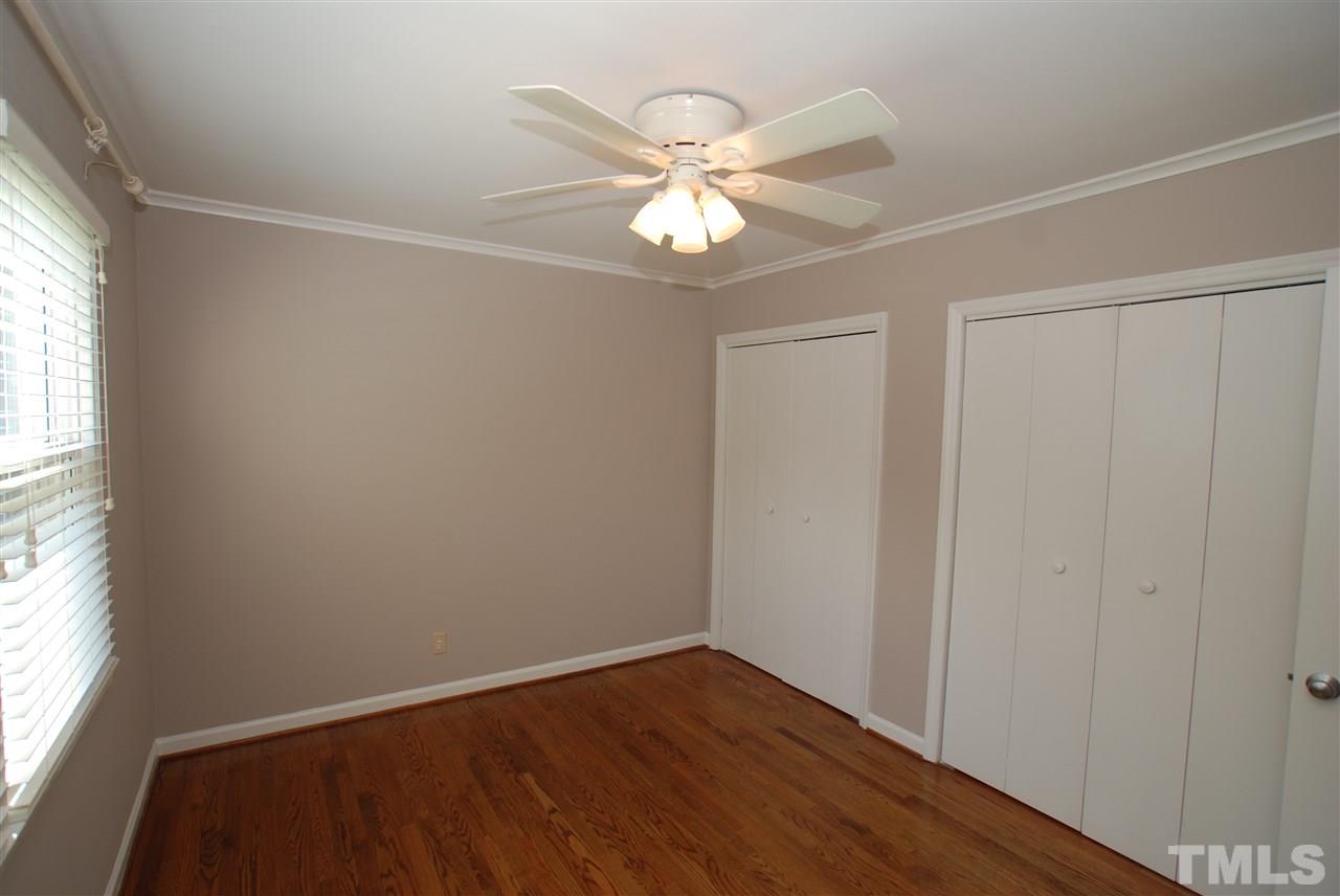 803 Daniels Street, Unit B Raleigh, NC 27605 - Photo 7 of 22 an empty room with wooden floor fan and windows