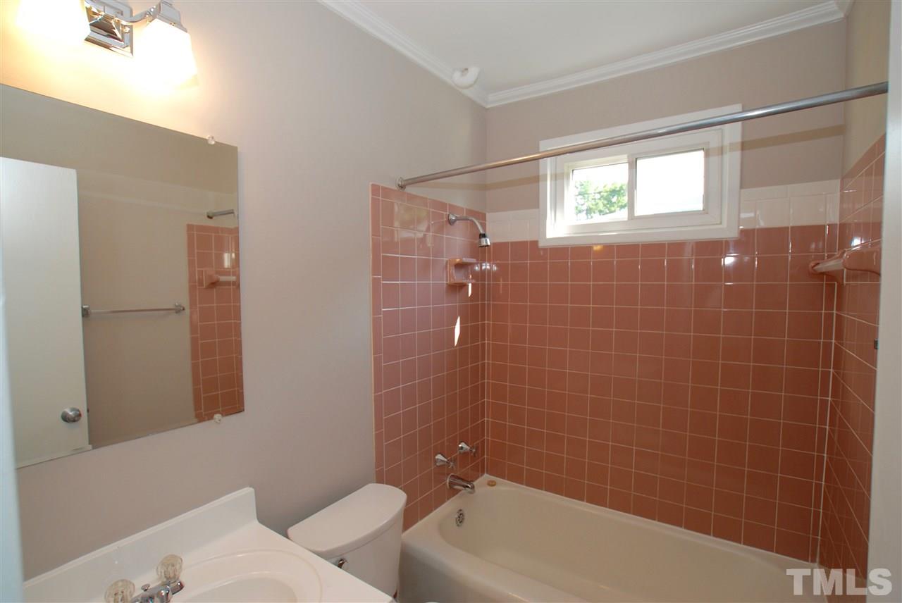 803 Daniels Street, Unit B Raleigh, NC 27605 - Photo 9 of 22 a bathroom with a bathtub a window a shower and vanity