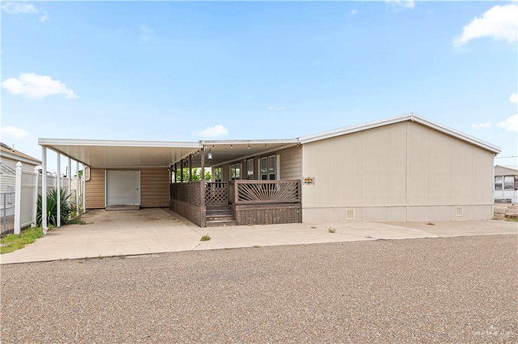 215 South Valley View Road, Unit 252 Donna, TX 78537 - Photo 1 of 19 Exterior featuring a covered carport, covered porch with decorative railing, and light-toned siding