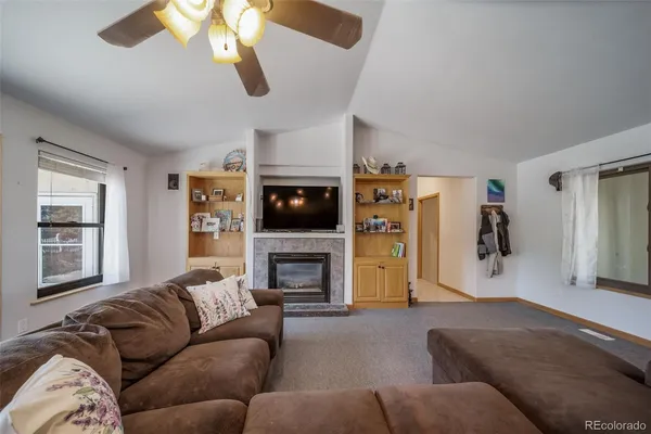 a living room with furniture a flat screen tv and a fireplace