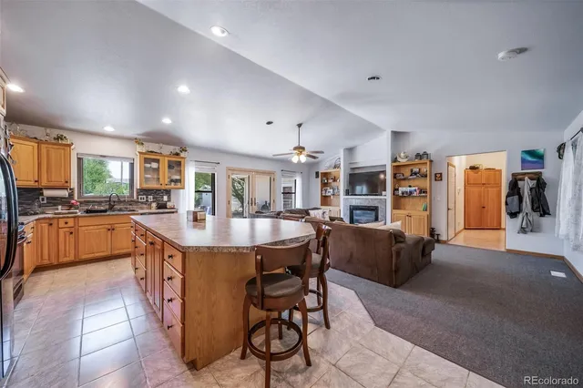 a dining hall with stainless steel appliances kitchen island granite countertop a table and chairs