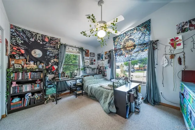 a bedroom with a bed a bookshelf and a window