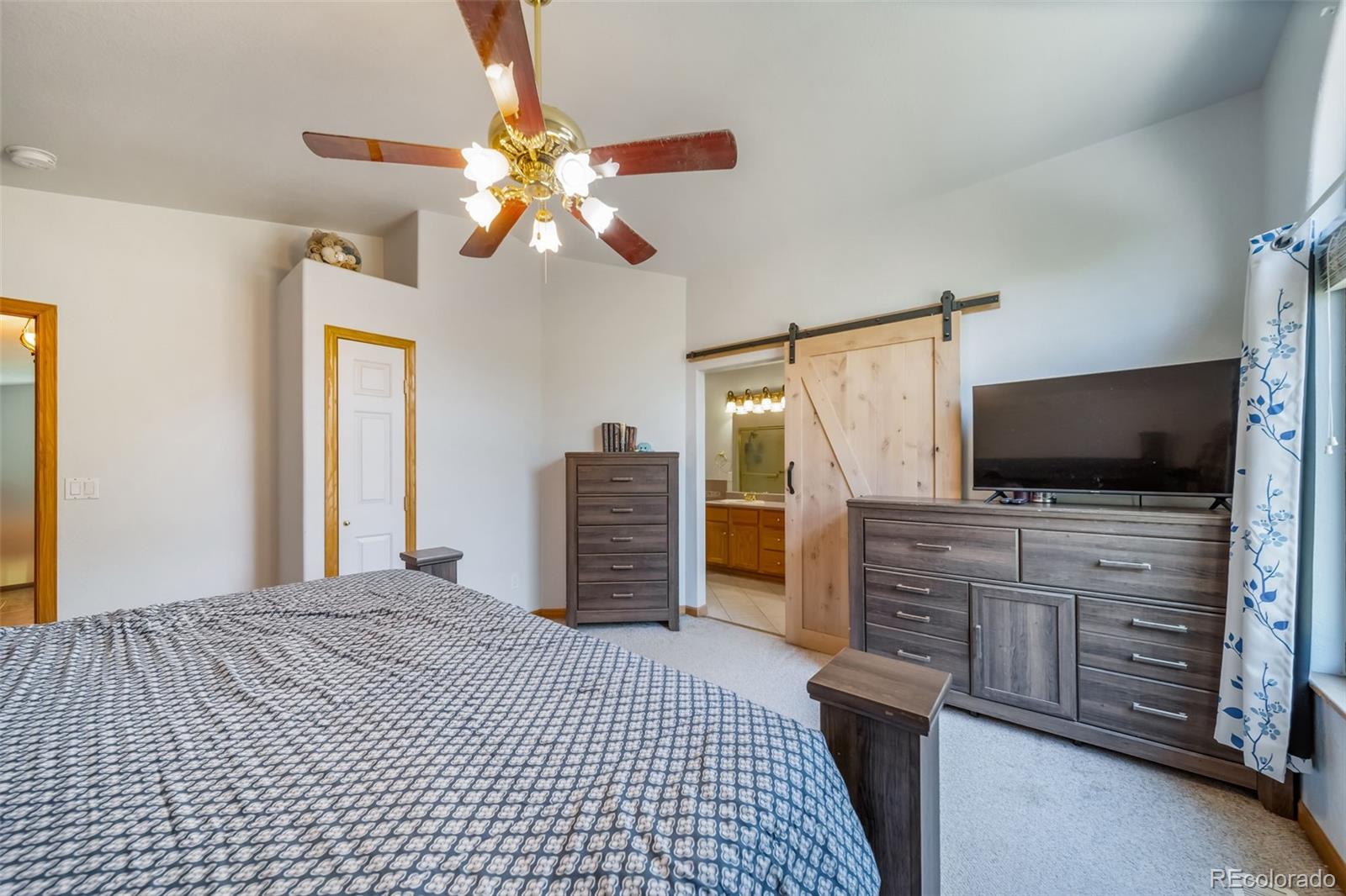 305 Kimble Avenue Swink, CO 81077 - Photo 20 of 44 a bedroom with a bed and a flat screen tv
