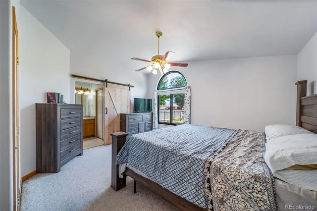 a bedroom with a bed a dresser and window