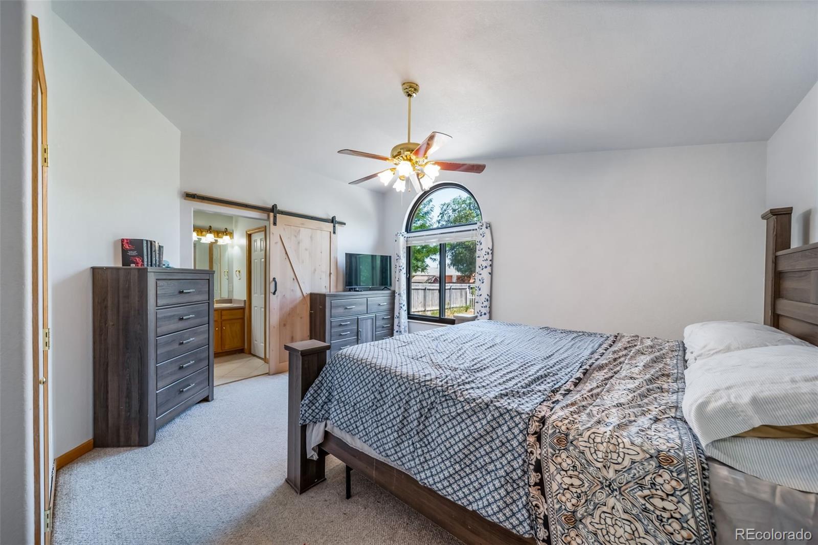 305 Kimble Avenue Swink, CO 81077 - Photo 24 of 44 a bedroom with a bed a dresser and window