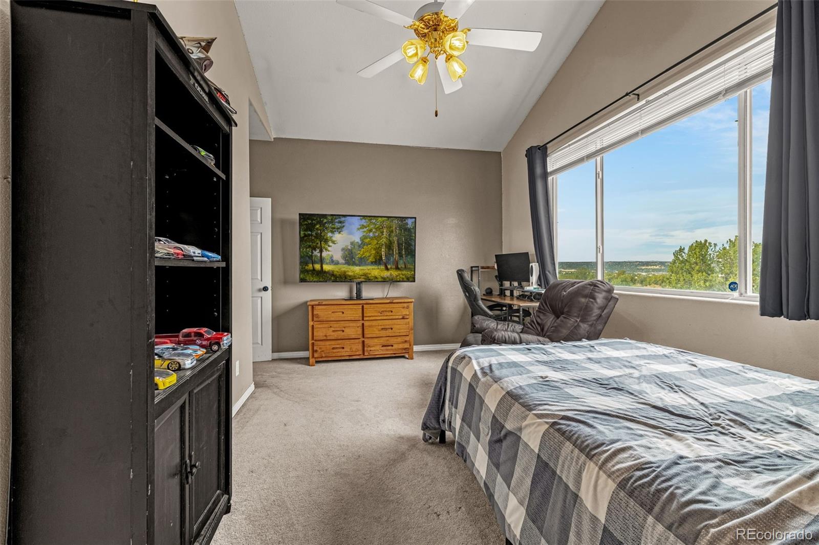 3115 Canyon Heights Road Pueblo, CO 81005 - Photo 21 of 44 a bedroom with a bed and a flat tv screen on dresser