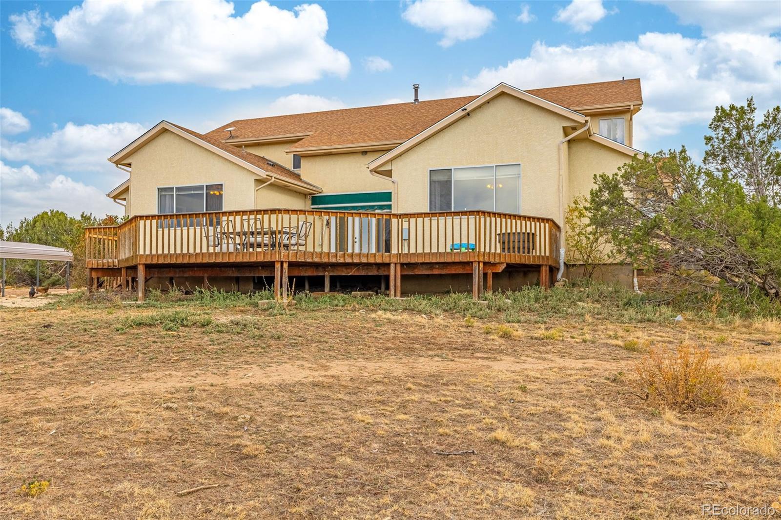 3115 Canyon Heights Road Pueblo, CO 81005 - Photo 41 of 44 a view of a house with a yard and a wooden deck