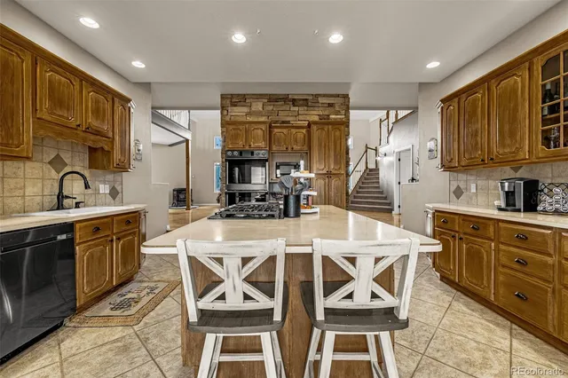 a kitchen with stainless steel appliances kitchen island granite countertop a sink and cabinets