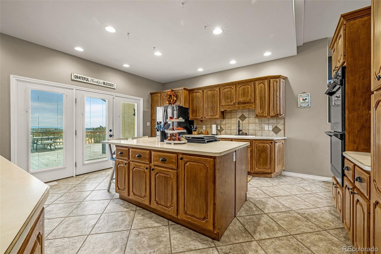 3115 Canyon Heights Road Pueblo, CO 81005 - Photo 7 of 44 a kitchen with stainless steel appliances granite countertop a stove a sink and a refrigerator