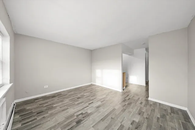 a view of empty room with wooden floor