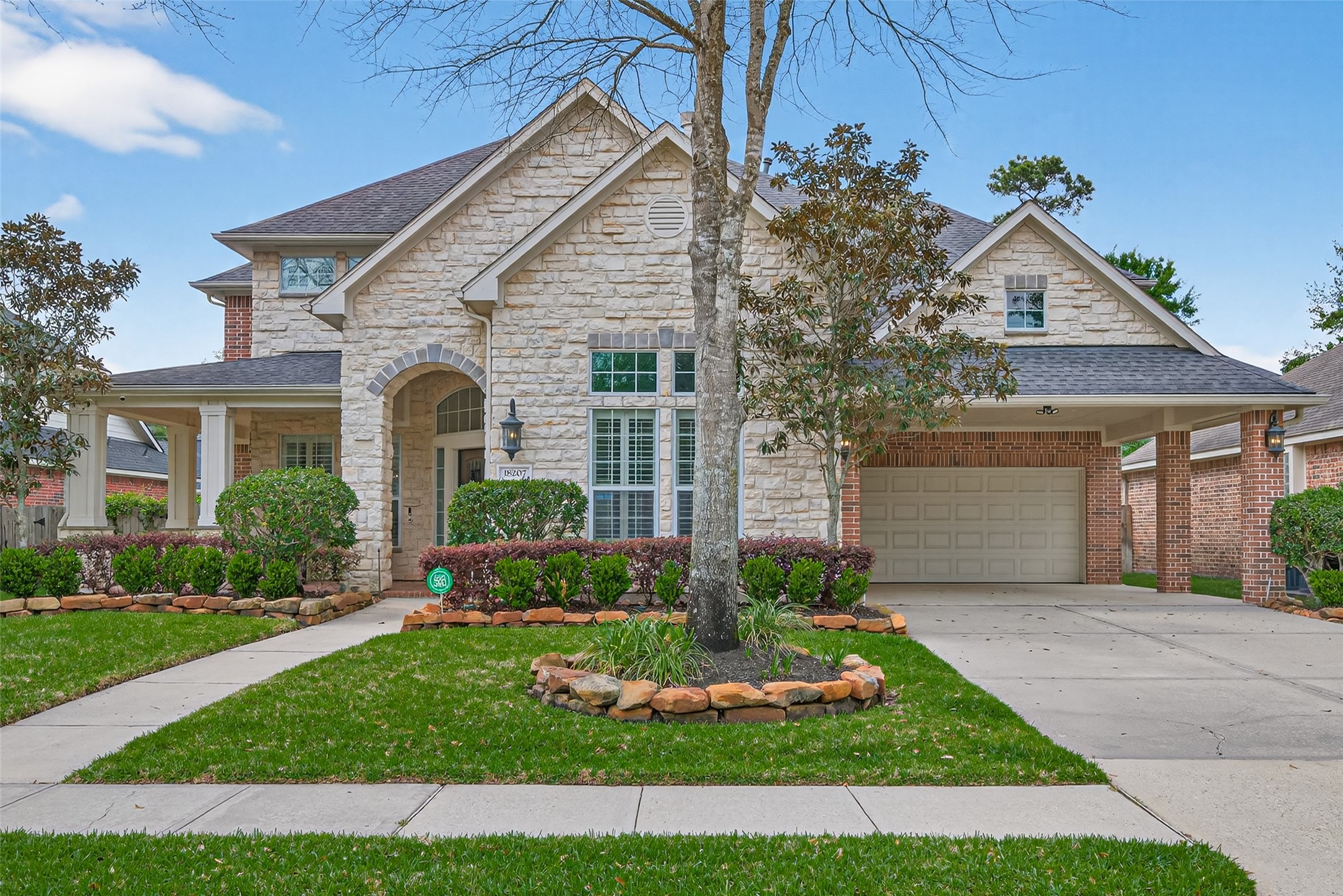 18207 Yukon Ridge Trail Humble, TX 77346 - Photo 1 of 49 This charming two-story home features a stone facade with a welcoming front porch and an attached two-car garage. The well-maintained front yard includes lush greenery and a stone-bordered walkway, adding to its curb appeal.