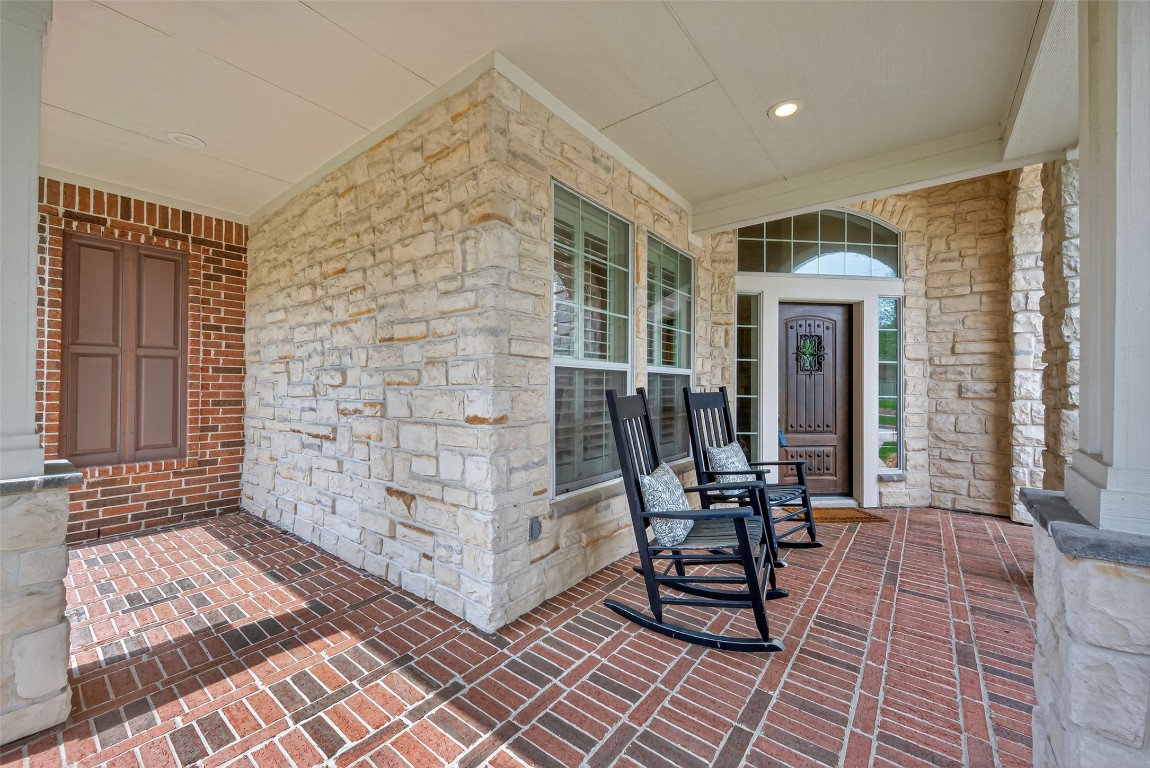 18207 Yukon Ridge Trail Humble, TX 77346 - Photo 4 of 49 This inviting front porch features elegant stonework and brick flooring perfect for relaxing. The arched entryway and updated front door add charm and natural light.