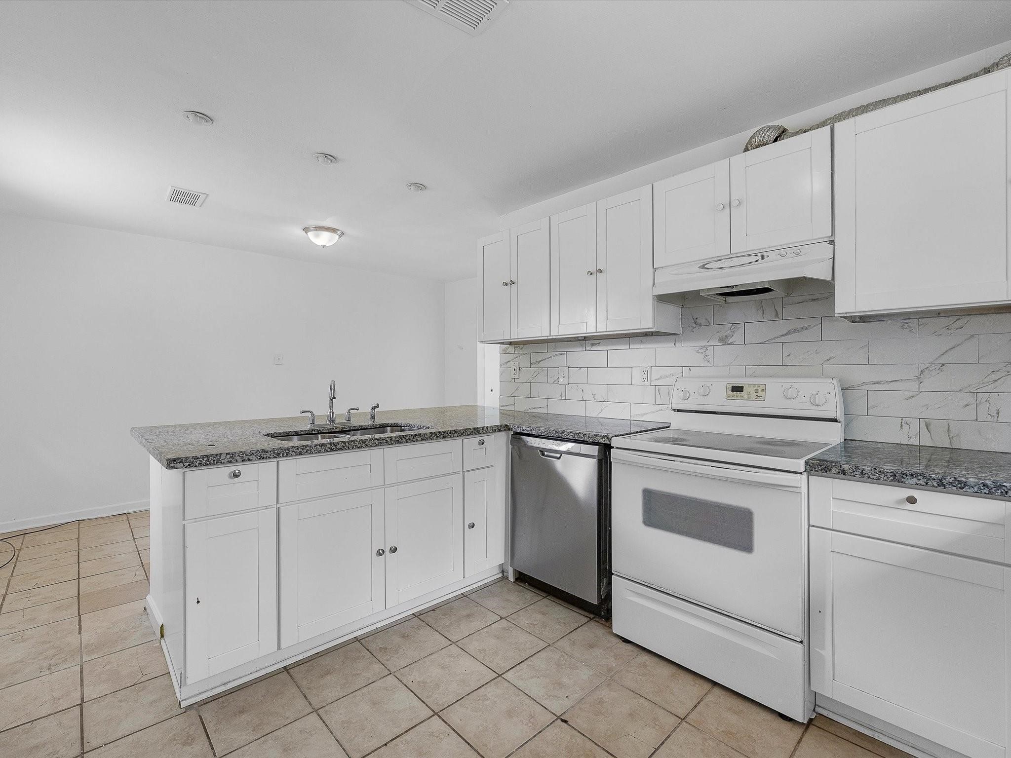 8161 Record Street Houston, TX 77028 - Photo 6 of 12 a kitchen with granite countertop white cabinets and white appliances