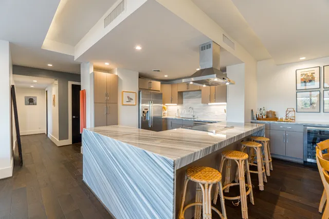 a view of a kitchen with granite countertop a sink stainless steel appliances and cabinets