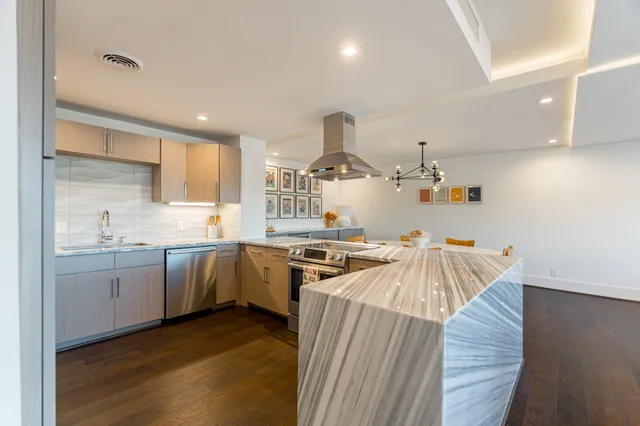 a kitchen with stainless steel appliances a sink stove and cabinets
