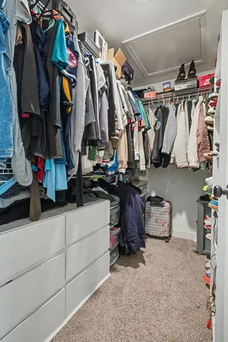 a view of walk in closet with clothes and shoes
