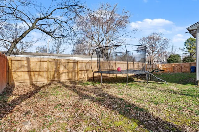 a view of backyard with wooden fence