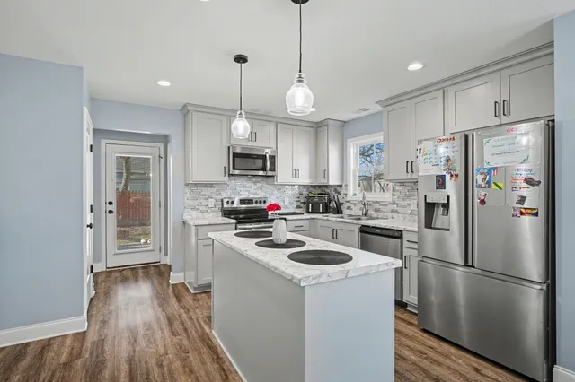 a kitchen with a refrigerator a stove top oven a sink and cabinets