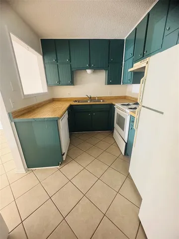 a kitchen with kitchen island a stove a sink and a refrigerator