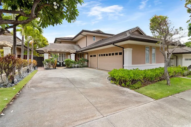 a front view of a house with a yard and potted plants