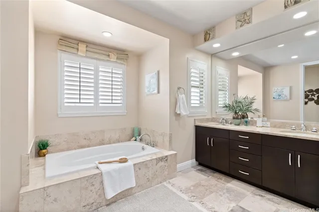 a spacious bathroom with a tub sink shower and mirror