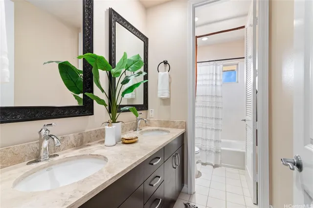 a bathroom with a granite countertop sink a potted plant and a shower