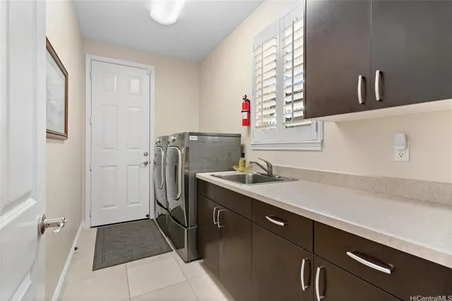 a utility room with cabinets washer and dryer