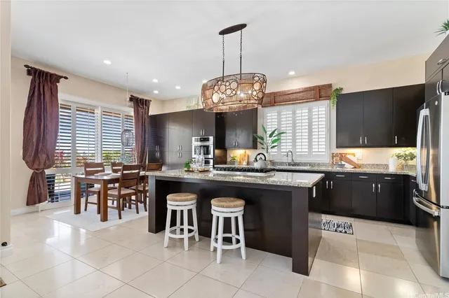 a kitchen with lots of counter top space dining table and stainless steel appliances