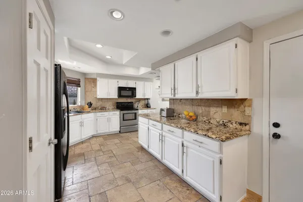 a kitchen with white cabinets and white appliances
