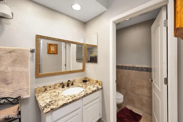 a bathroom with a granite countertop sink and a mirror