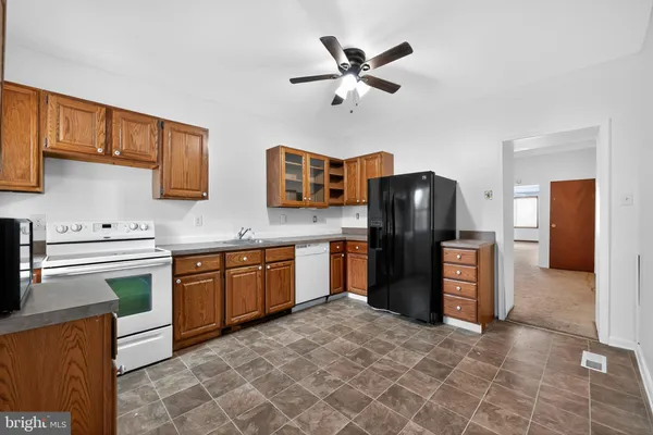 a kitchen with stainless steel appliances granite countertop a refrigerator a stove a sink and dishwasher