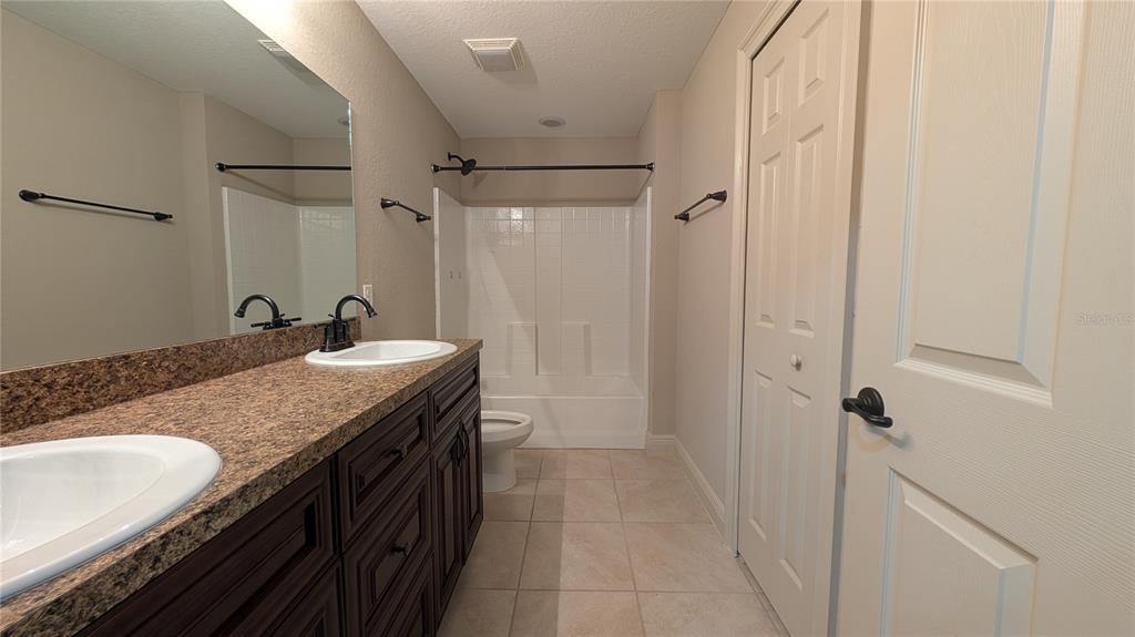 8802 Southwest 135th Place Ocala, FL 34473 - Photo 19 of 39 a bathroom with a granite countertop sink a mirror and a shower