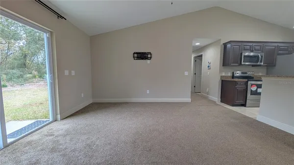 an empty room with a window and a ceiling fan